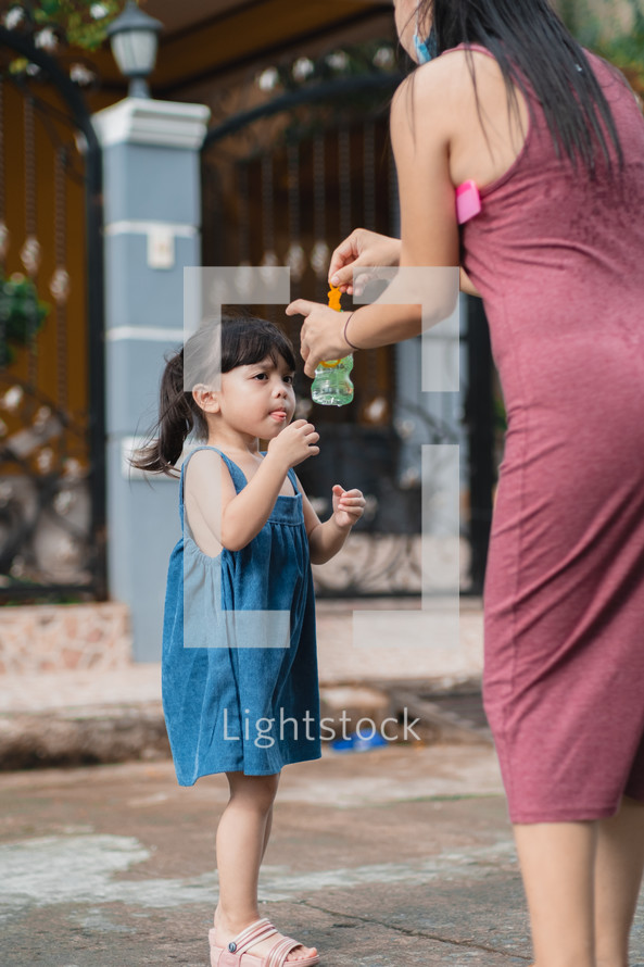 mother and daughter blowing bubbles 