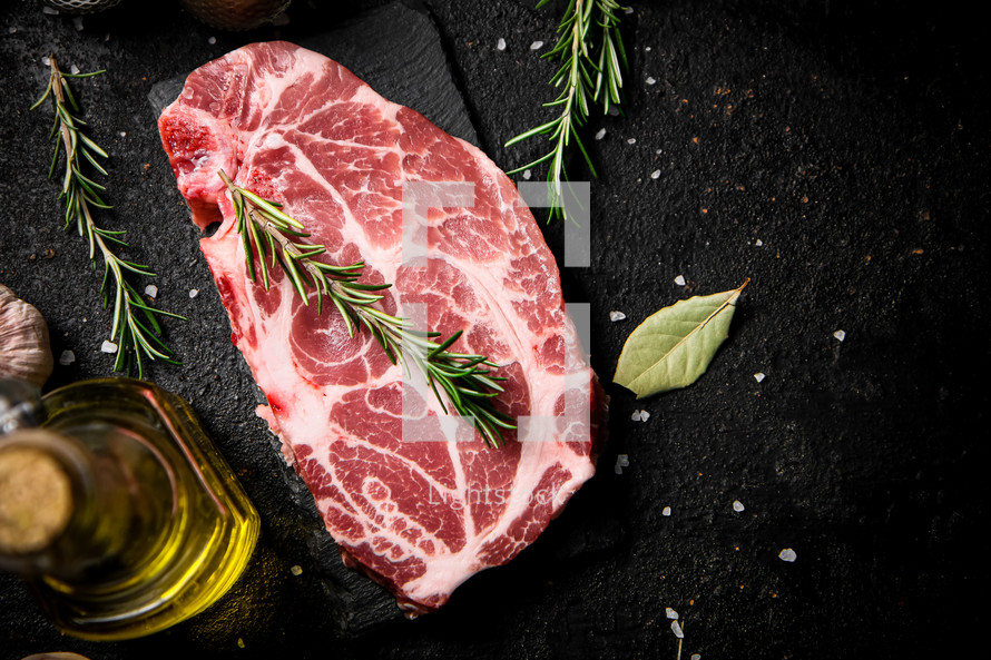 Raw pork steak on a stone board. On a black background. High quality photo