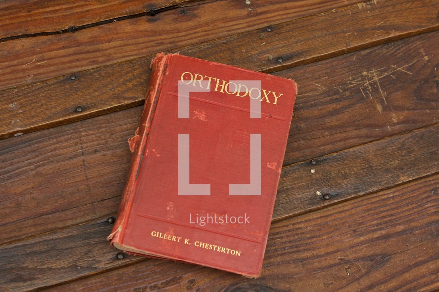 old hardback book lying on wood table - floor