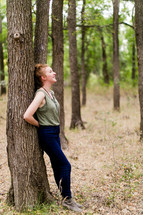 woman leaning on a tree outdoors 