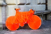 bicycle wrapped in orange string 