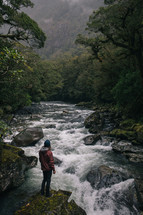 man standing near river rapids in New Zealand 