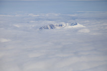 snow capped mountain peak above the clouds 
