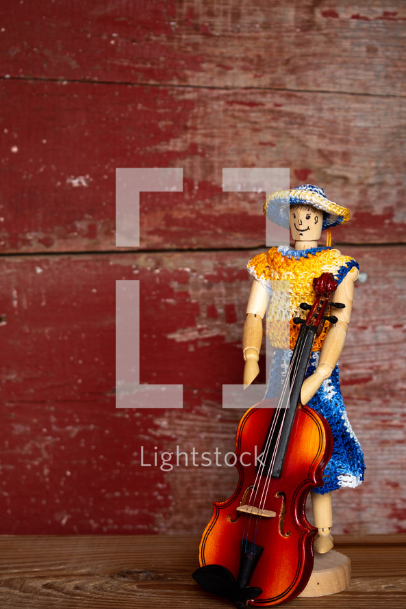 knit clothes on a figurine and violin 