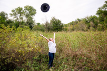 woman tossing her hat in the air 