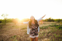 woman with open arms rejoicing outdoors 