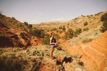 a woman exploring a desert landscape 