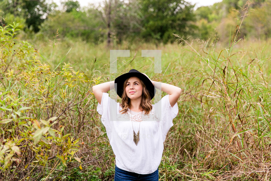 woman posing with a hat outdoors 