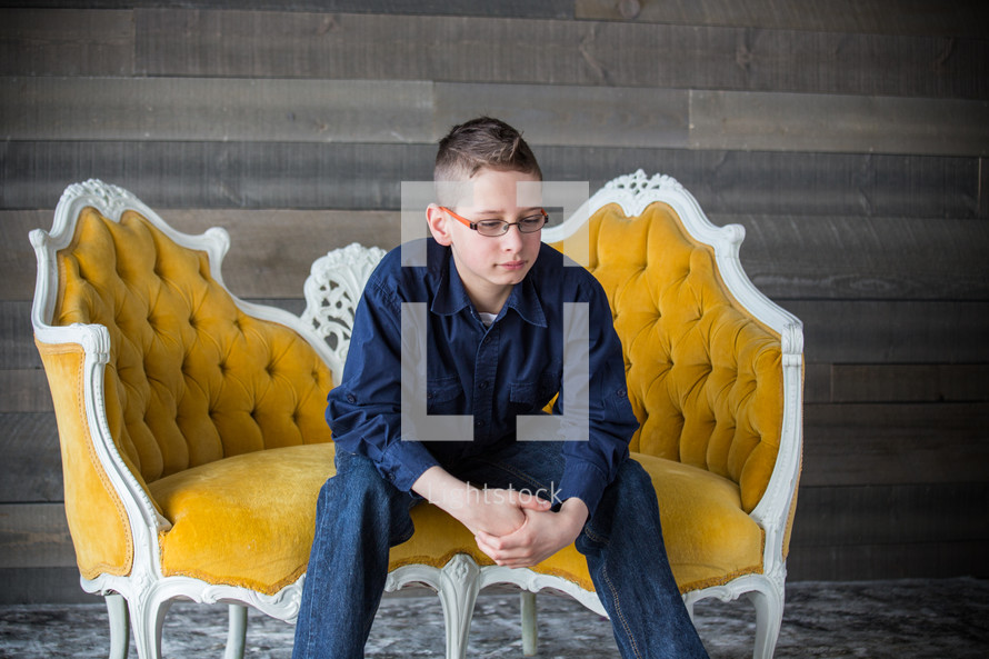 a teen sitting on a couch thinking 