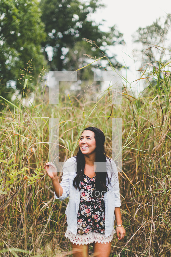woman standing outdoors in tall grasses 