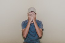 a man covering his face with his hands 