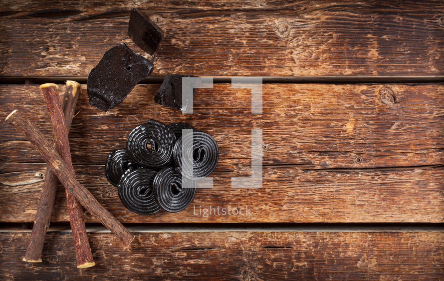 licorice, roots, pure blocks and candy on wooden table