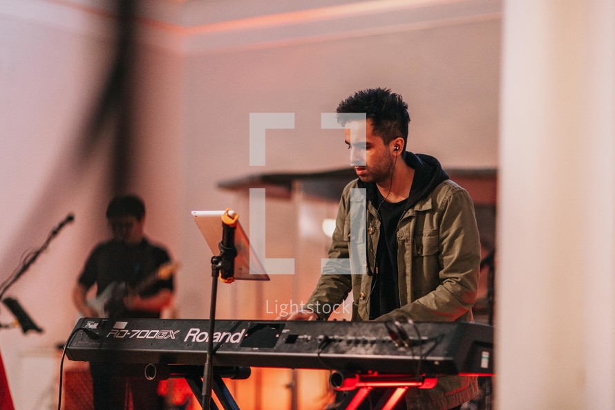a man playing a keyboard during a worship service 