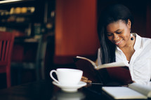 woman reading from a journal at a coffee house during a Bible study