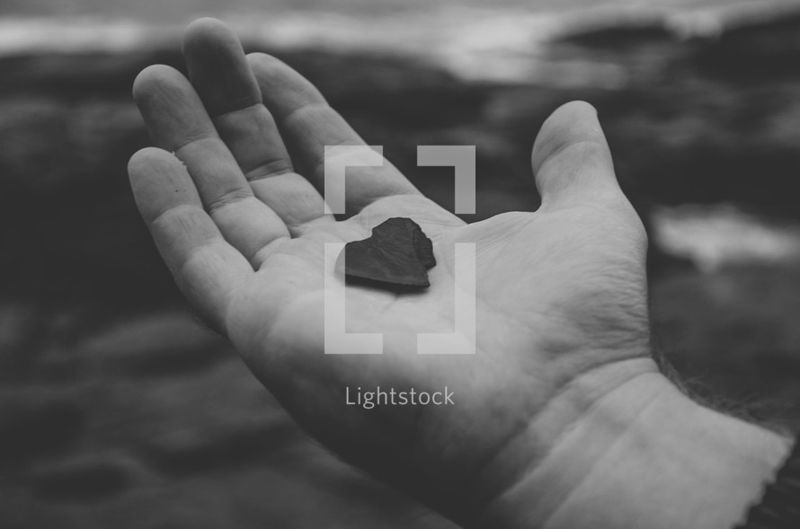 man holding a heart shaped rock 