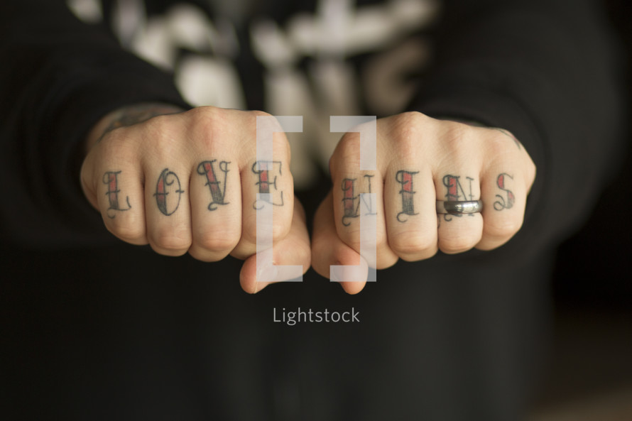 love wins in tattoos on a man's knuckles 