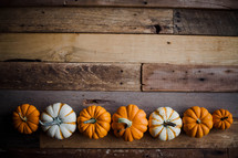 row of pumpkins on wood boards 