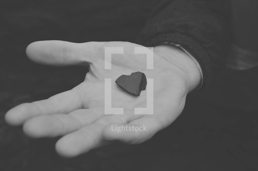 man holding a heart shaped rock 