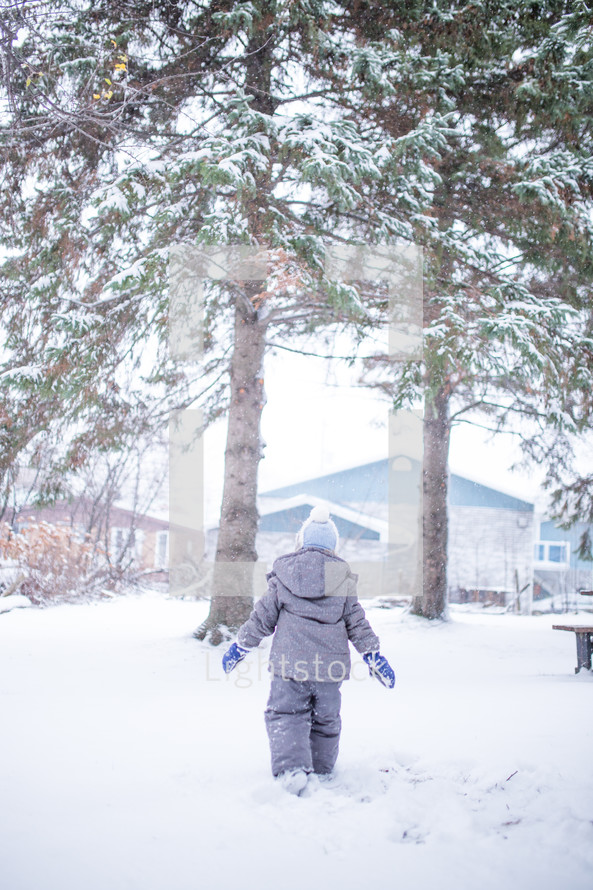 a boy child walking through snow 