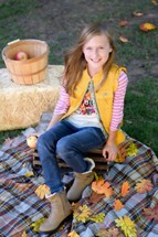 fall portrait of a young girl on a plaid blanket 