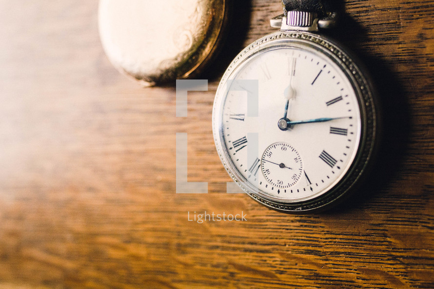 pocket watches on a wood table 