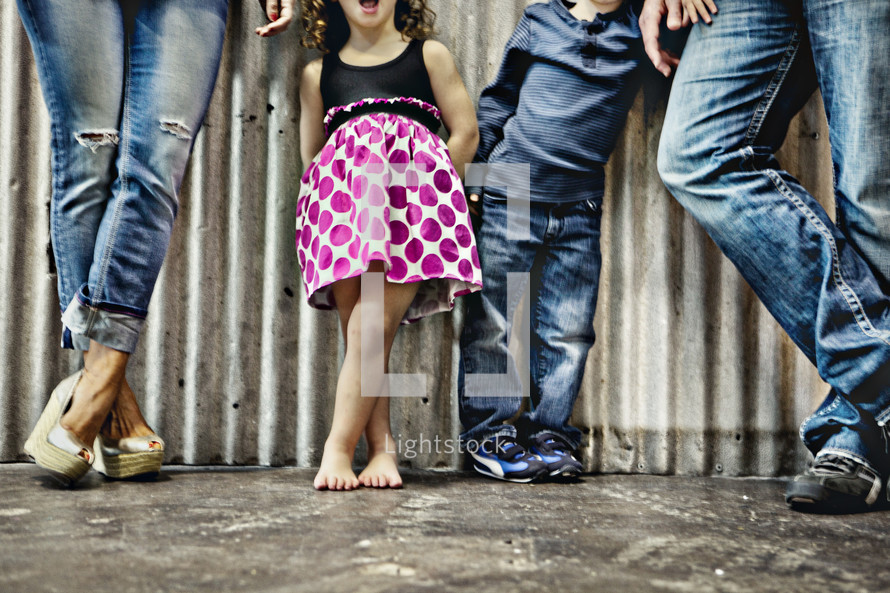 legs of a family in denim and a dress
