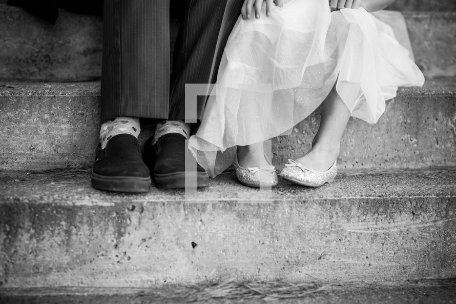 feet of a father and daughter sitting on steps 