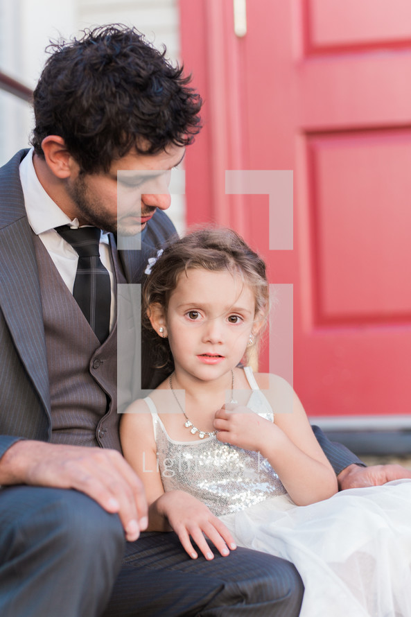 a father and daughter sitting on the steps of a church 