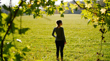 woman standing in a field of cut green grass 