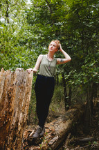 woman standing outdoors near a fallen tree