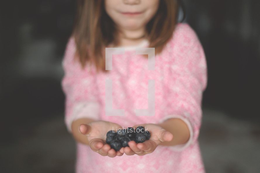 girl child holding blueberries 