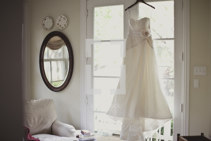 Bridal gown hanging in a window