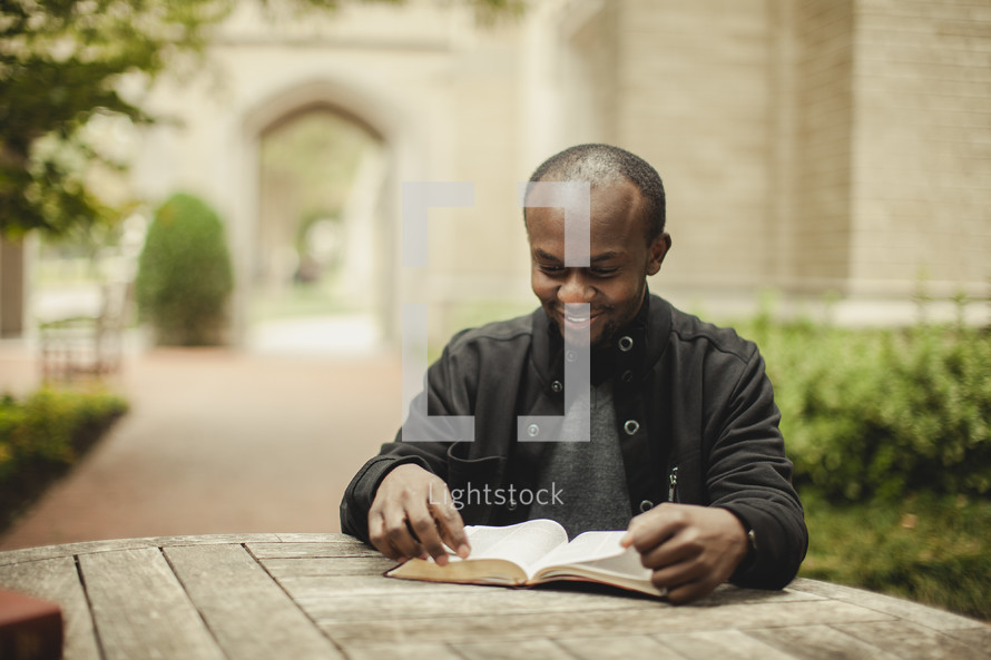 Man reading BIble outdoors