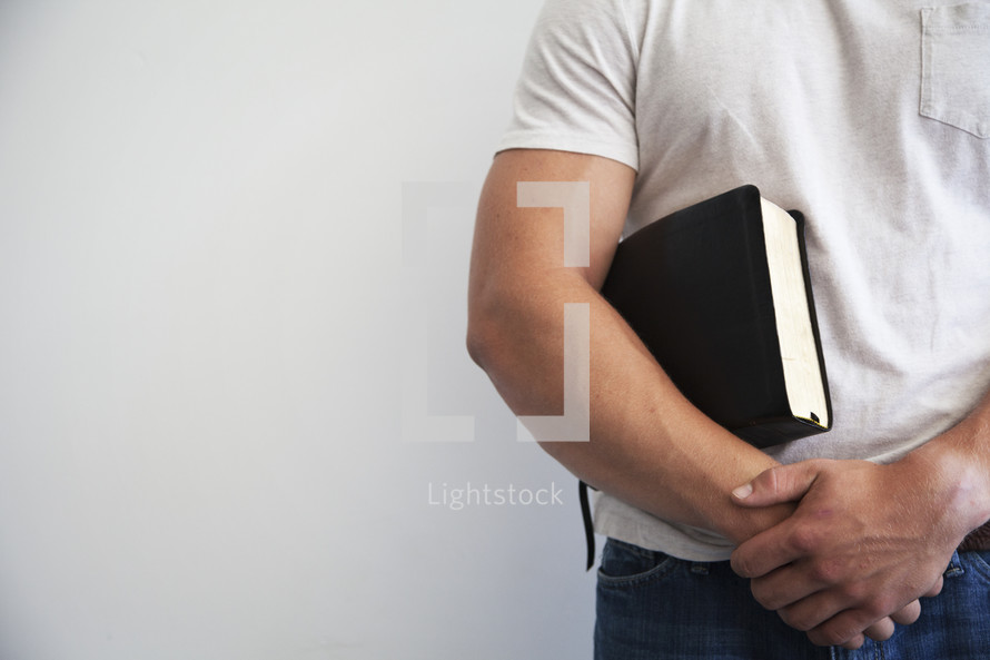 man holding a Bible to his chest 