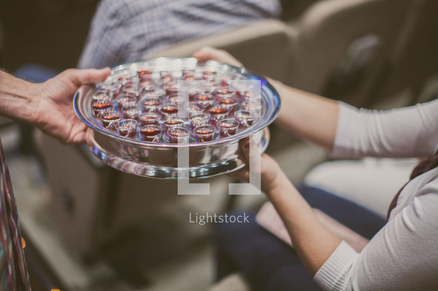 passing a tray of communion wine cups 
