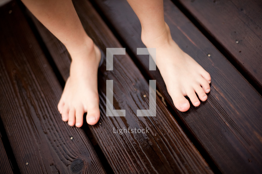 kids bare feet on a deck 