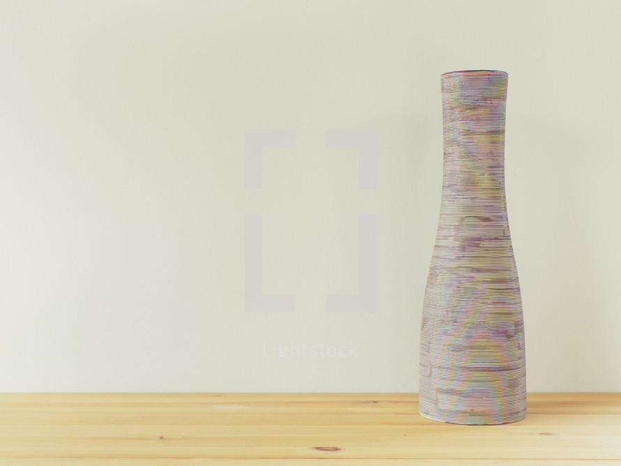 a pottery jar on a wood table 
