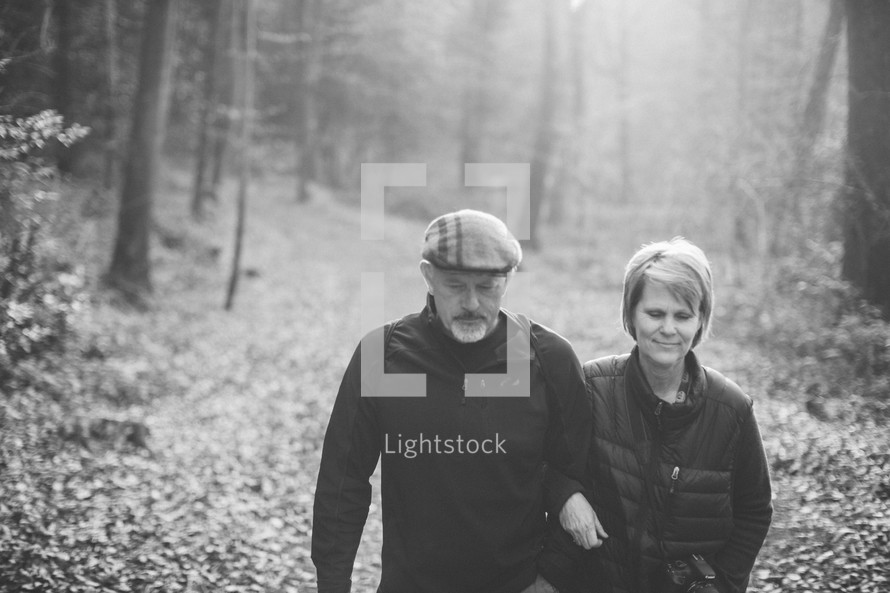 couple walking arm in arm on a trail 