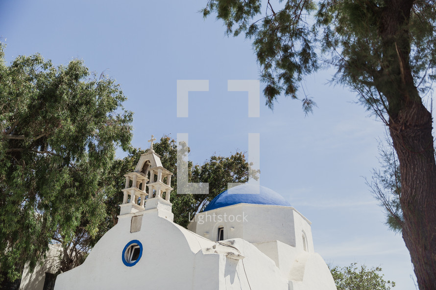 A white stucco church with a blue dome.