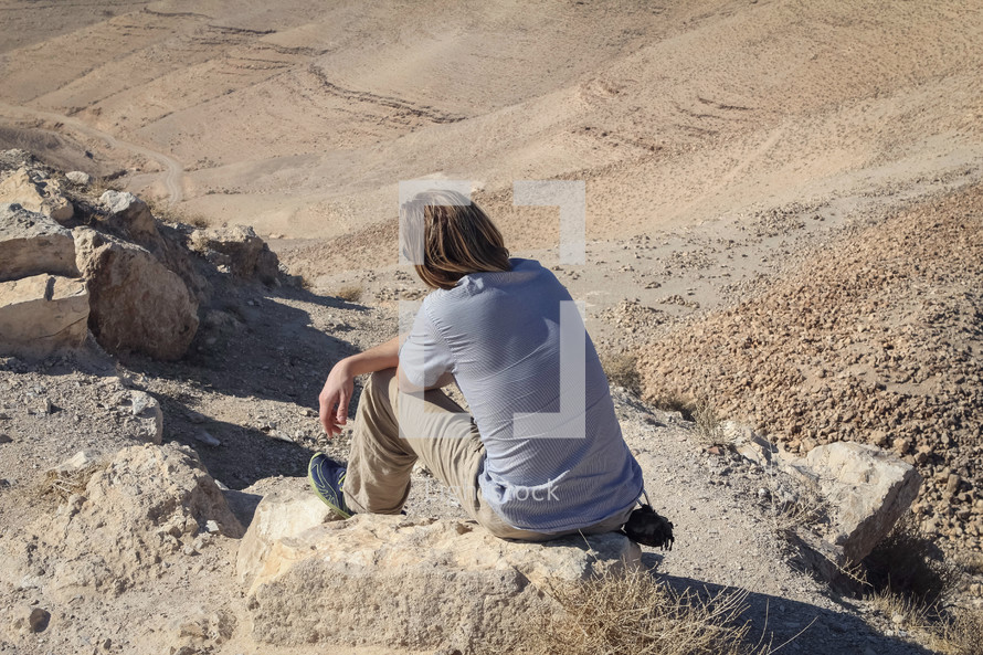 a person sitting in the desert in Jordan 