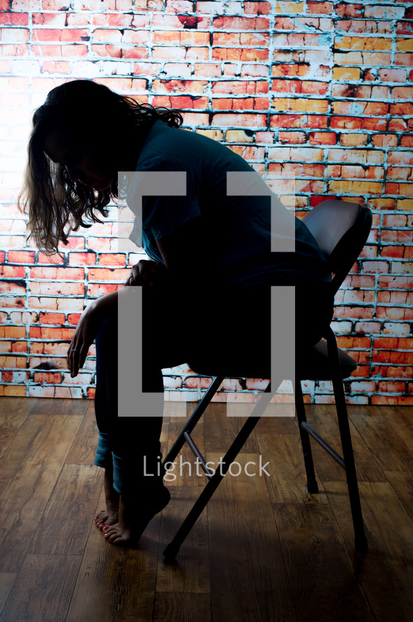 depressed woman sitting in a folding chair 