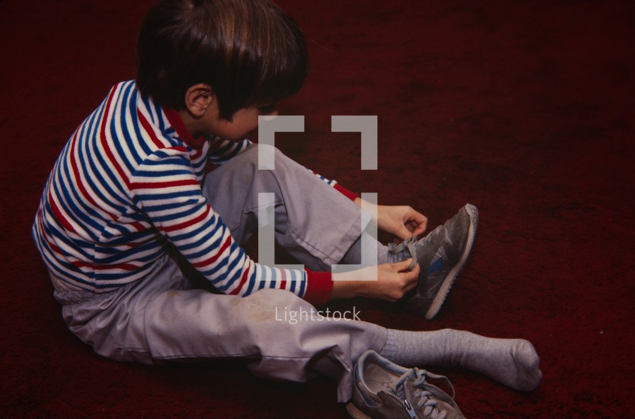 child tying his shoes 