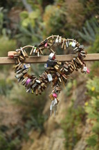 locks in the shape of two hearts hanging on a fence