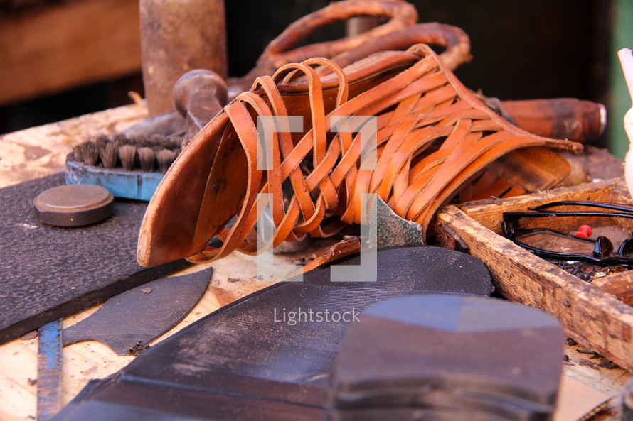 Leather sandals being made by hand by a cobbler.