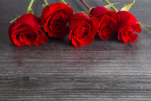 long stem roses on a wood background 