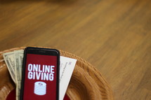 cellphone with an online giving app in an offering plate 