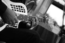 man playing a steel guitar slide capo 