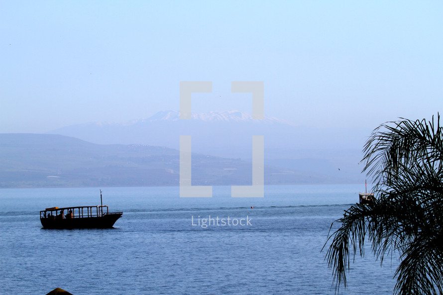 Boat on the Sea of Galilee with mountain in the background