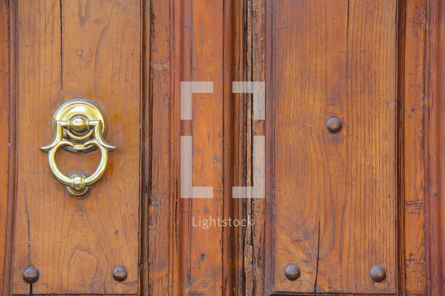 Brass door knocker on an old wooden door