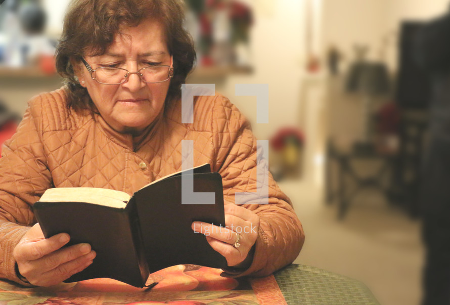 an elderly woman reading a Bible 